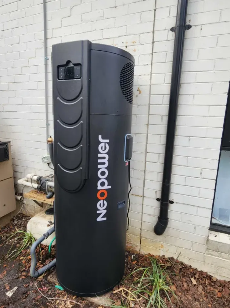Neopower heat pump installed beside a brick house