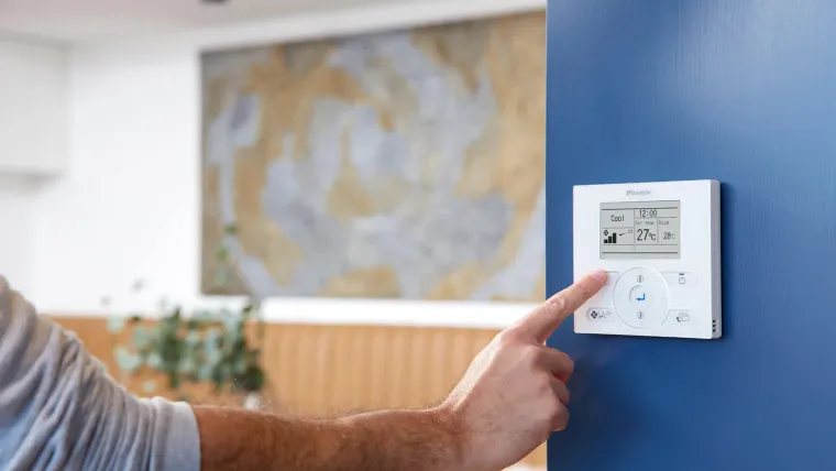 Hand adjusting a Daikin wall controller