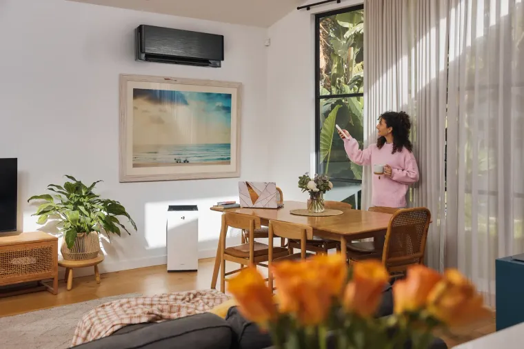 Woman adjusting a Daikin wall-mounted indoor unit