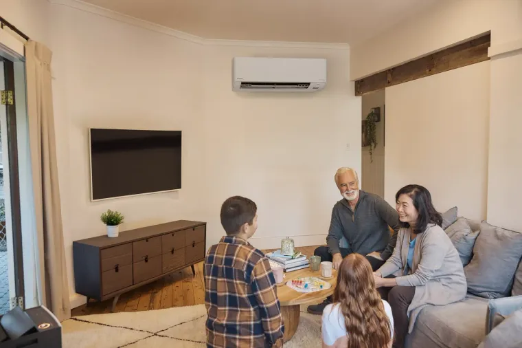 Family in a living room with a Daikin wall-mounted indoor unit